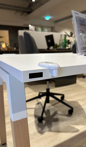 EnoSense® DESK befestigt auf einer moderenen Schreibtischplatte an der linke Ecke